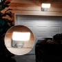 Weiße Philips Tylus Solar-Wegeleuchte mit Bewegungssensor, 5000 K, 1000 lm an einer Holzwand.