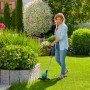 Frau trimmt Rasen mit Gardena Akku-Trimmer EasyCut 23/18V P4A im Garten.