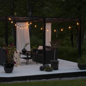 Konstsmide LED Biergarten Lichterkette mit bernsteinfarbenen Leuchtmitteln im Garten.