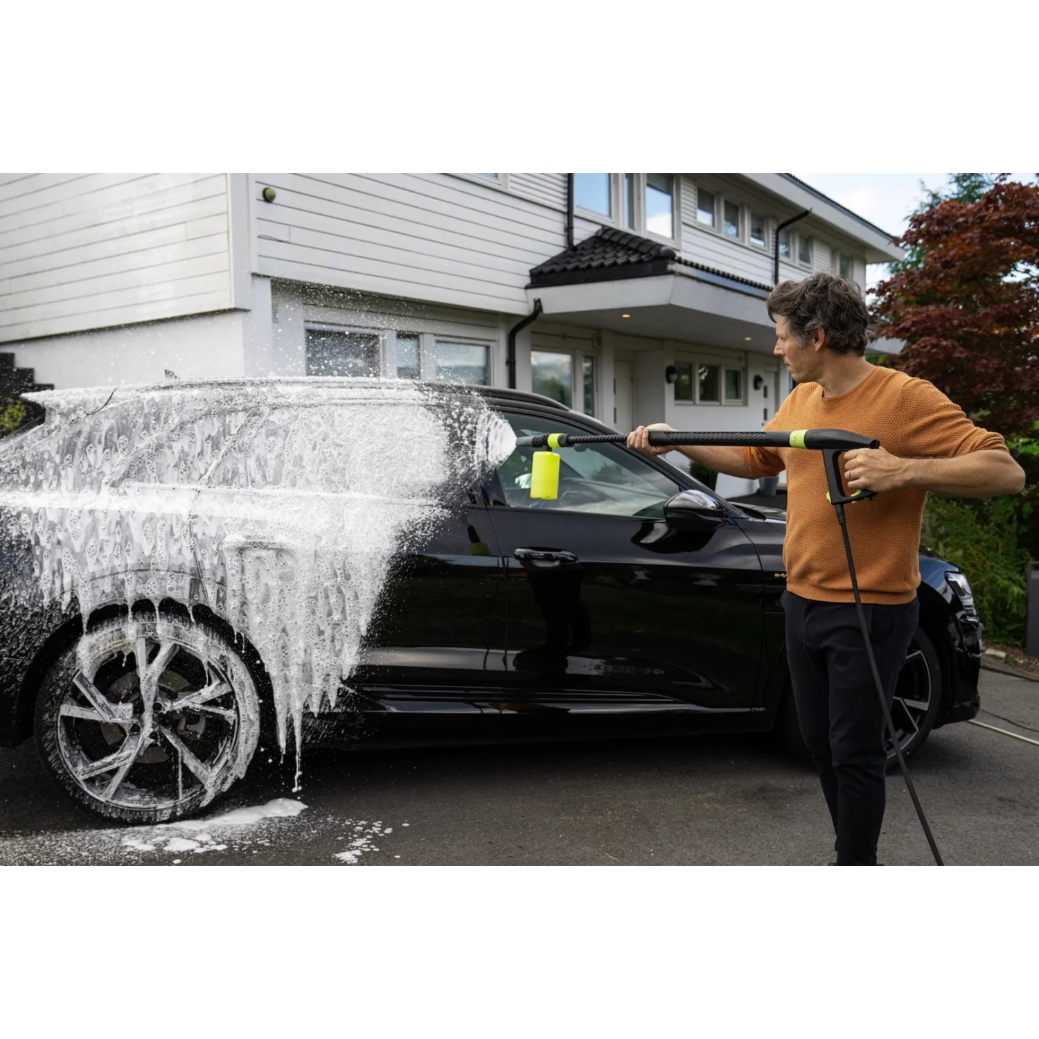 AVA Evolution P60 Hochdruckreiniger im Einsatz: Mann reinigt Auto mit Schaum. Ideal für die Autowäsche.
