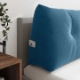 Blaues Samt-Rückenkissen mit Knöpfen und praktischer Seitentasche auf einem Bett. Ideal als bequeme Bettrückenlehne.