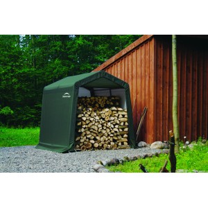 Grünes ShelterLogic Foliengerätehaus (5,76 m²) mit Holzfüllung vor Holzwand.