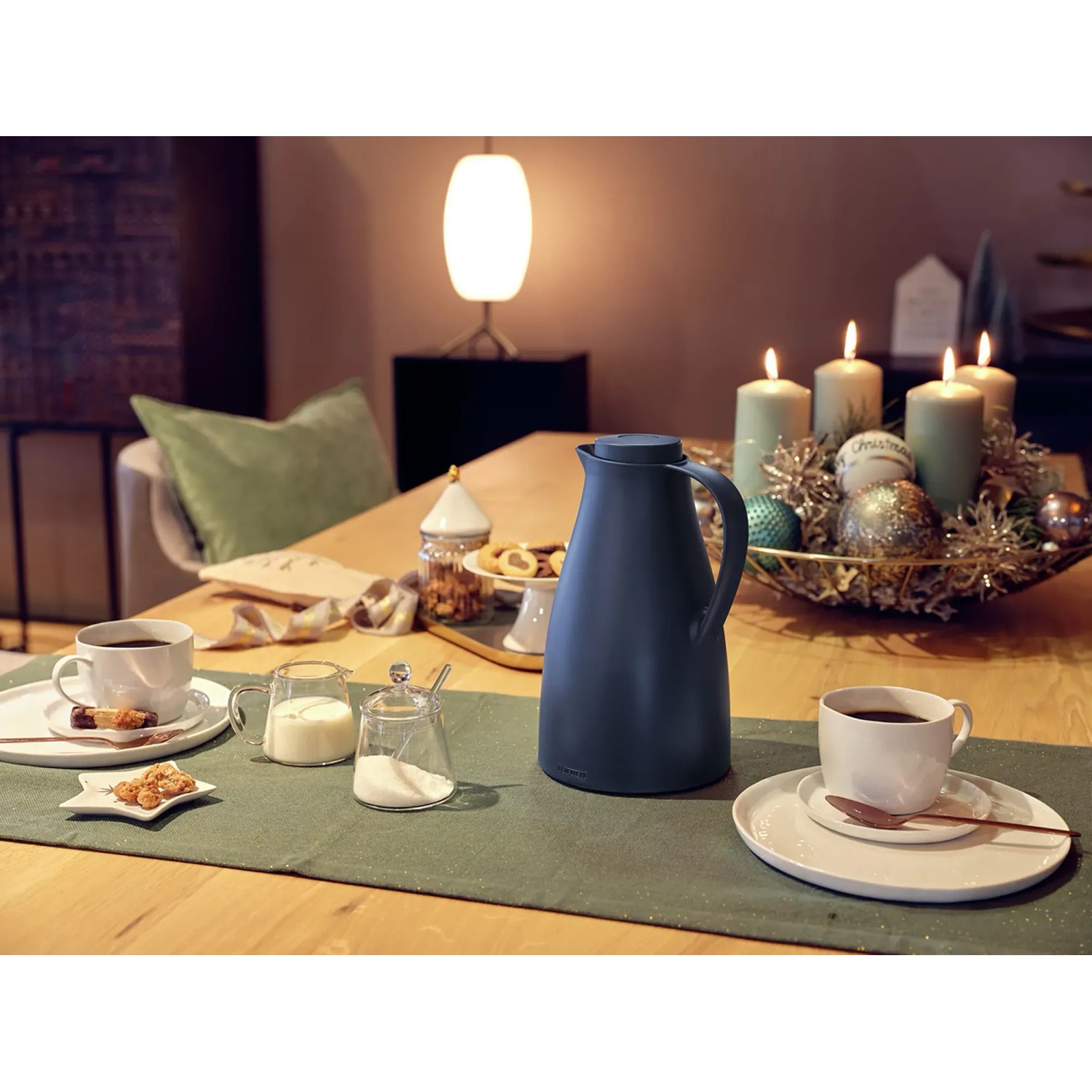 Dunkelblaue Isolierkanne Harmonic 1 l von Leifheit auf gedecktem Tisch mit Geschirr.