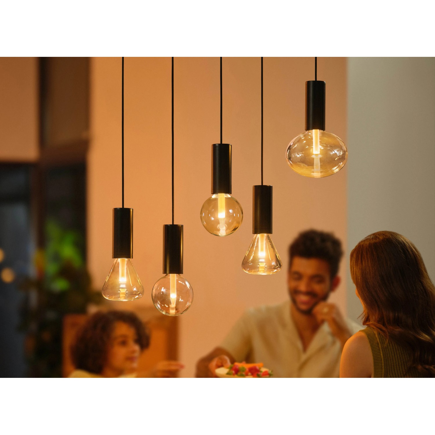 Philips Hue Lightguide Lampen mit schwarzer Kordel über Esstisch. Verschiedene Formen.