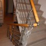 Edelstahl-Endkappe V2A (Ø 52 mm) am Holzhandlauf eines Treppengeländers.