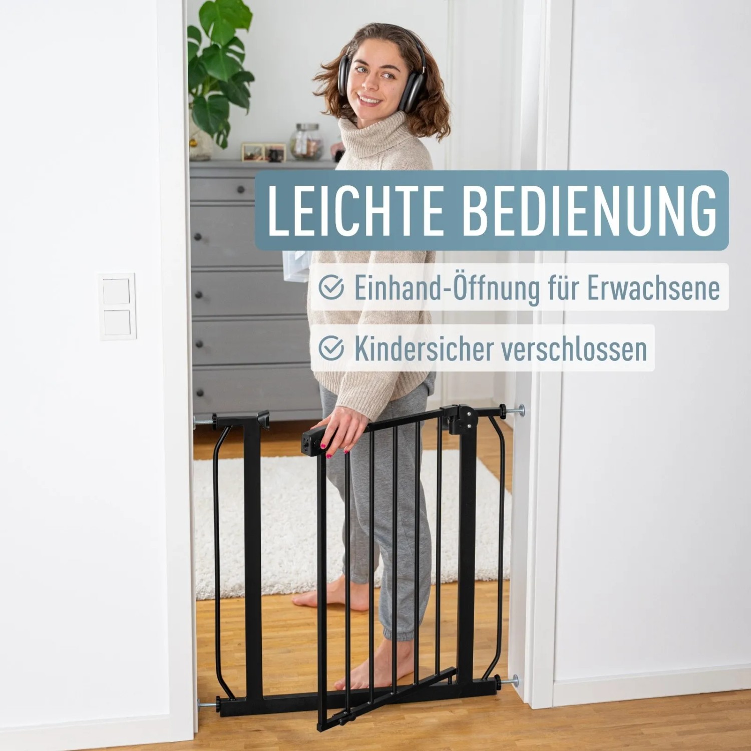 Schwarzes ib style Türschutzgitter Berrin, ohne Bohren, mit Frau im Hintergrund.