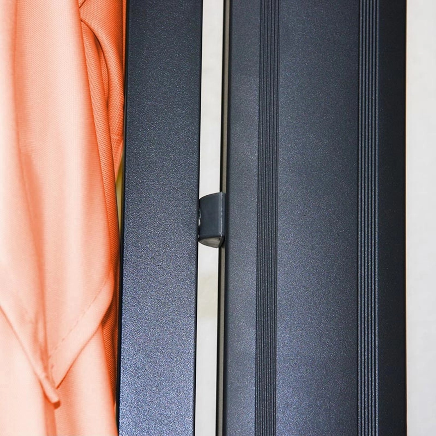 Detailaufnahme: Geschlossener, terracottafarbener MCW Ampelschirm A96 mit Aluminiumgestell.