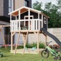 Karibu Stelzenhaus Benjamin mit Rutsche, Schaukel und Sandkasten im Garten.