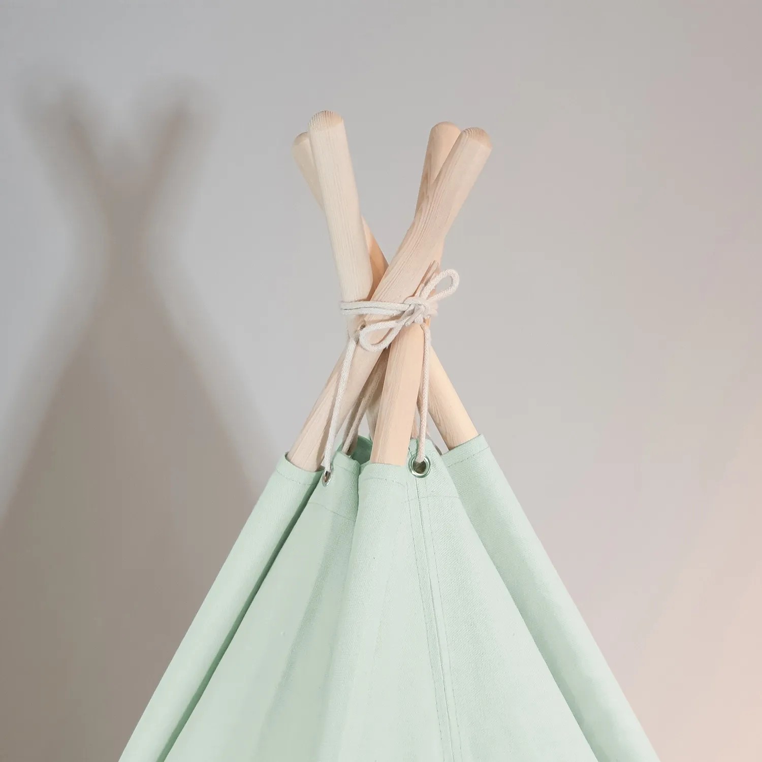 Detailaufnahme: Pastellgrünes Sunny Tipi Zelt Alba mit Holzstäben, ideal für Spiel & Spaß.
