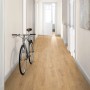 Verlegtes Egger NatureSense Aqua Laminat Eiche Predaia Honig im Flur mit Fahrrad an der Wand.