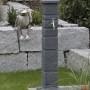 Arves Wasserzapfstelle Romana Black Granit mit Chromhahn im Garten.