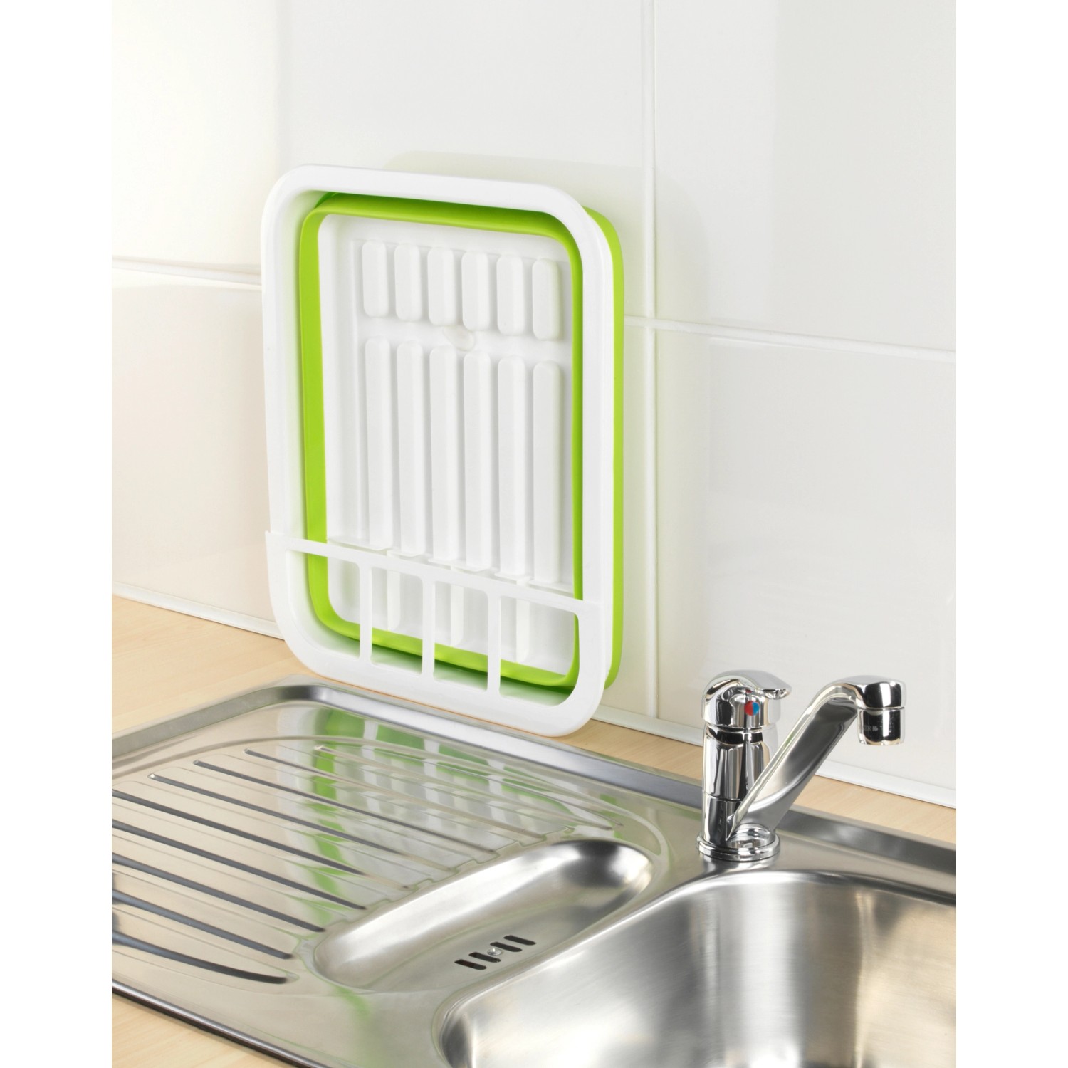 Faltbarer Wenko Geschirrabtropfer in Weiß-Grün neben einer Spüle.