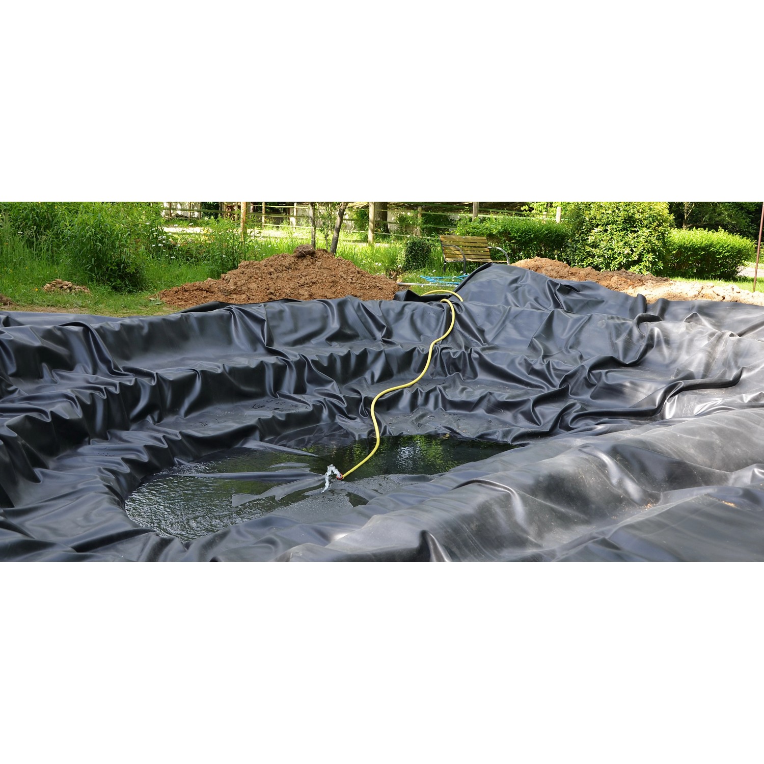 Schwarze Aquagart Teichfolie (1x2m) aus PVC im Gartenteich mit Wasser und gelbem Schlauch.