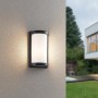 Moderne, schwarze Reality Außenwandleuchte Puelo mit zylindrischem Lampenschirm an Hauswand.