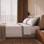 Elegantes weißes Baumwoll-Bettwäsche-Set für Einzelbett mit dunkelgrauer Satin-Bordüre und passenden Kissenbezügen.