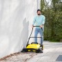 Gelbe Kärcher Kehrmaschine S6 Twin im Einsatz mit Mann. Ideal für Hof und Garten.