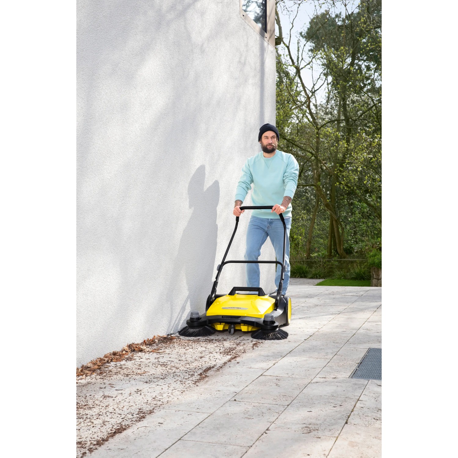 Gelbe Kärcher Kehrmaschine S6 Twin im Einsatz mit Mann. Ideal für Hof und Garten.