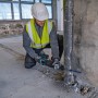 Handwerker mit Bosch Akku-Säbelsäge GSA 18V-28 beim Rohrzuschnitt auf einer Baustelle.
