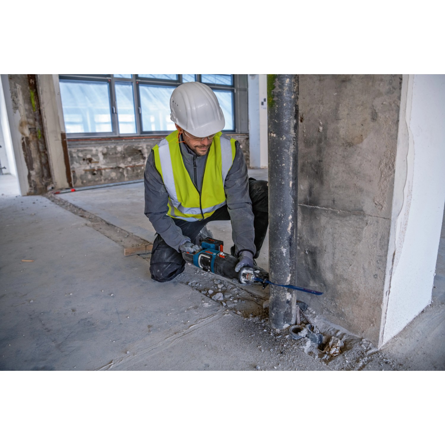 Handwerker mit Bosch Akku-Säbelsäge GSA 18V-28 beim Rohrzuschnitt auf einer Baustelle.