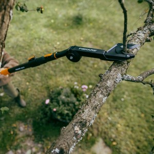 Fiskars Baumschere OneClick in Orange-Schwarz beim Schneiden eines Astes.