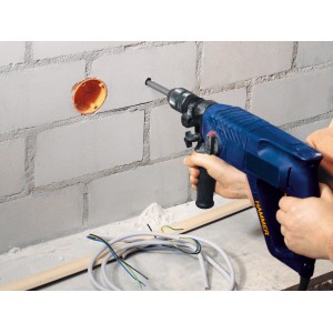 LUX Mauerdurchbruchbohrer Comfort im Einsatz an einer Wand mit Bohrloch und Kabeln.