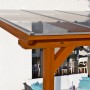 Skan Holz Terrassenüberdachung Bormio aus Leimholz in Nussbaum mit klarer Doppelstegplatte.