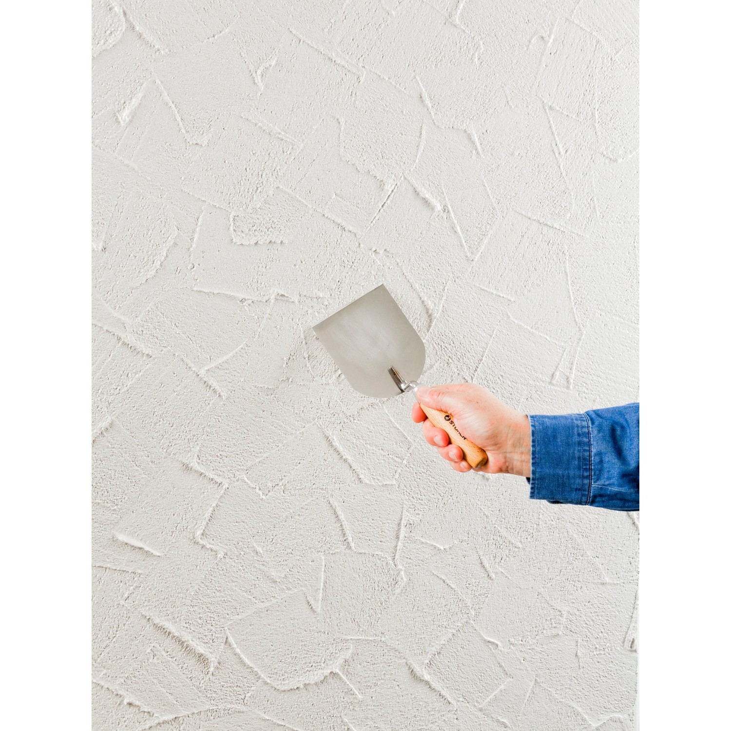 Auftragen von Knauf Diamant Mineralputz (2 mm) mit einer Kelle auf eine Wand.