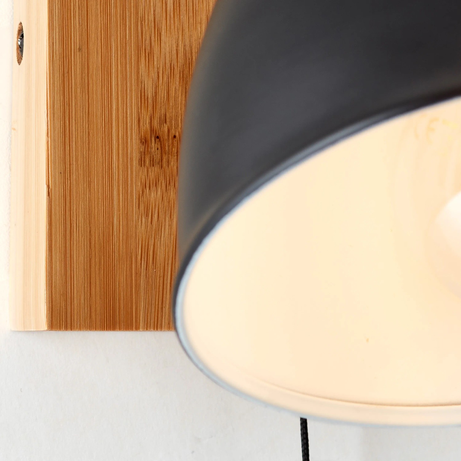 Detailaufnahme: Schwarze Wandleuchte Celia mit Bambus-Element für Innenräume.