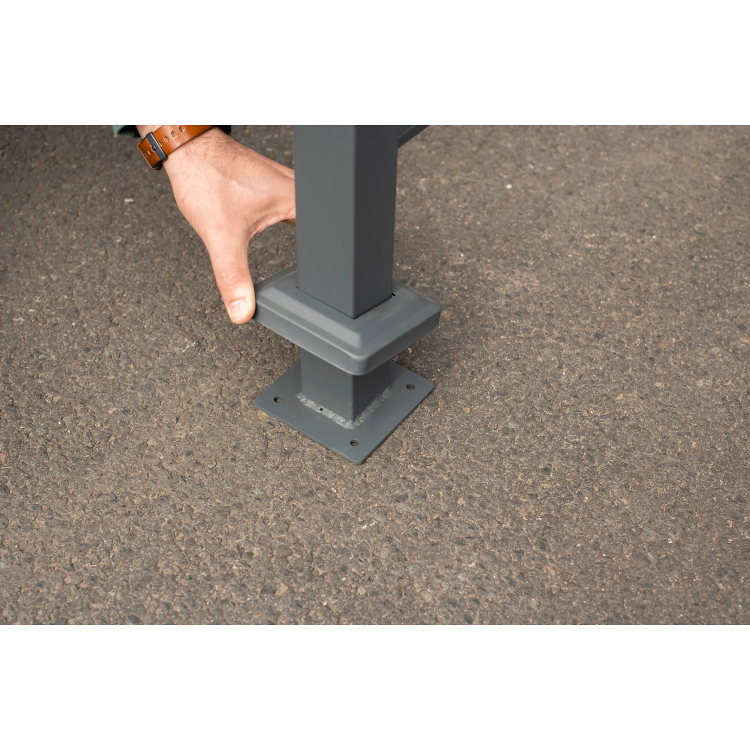 Detailaufnahme der Bodenbefestigung der Westmann Mülltonnenverkleidung Planum aus Metall.