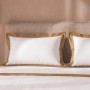 Weißes Bettwäsche-Set aus Baumwolle für Doppelbett mit beiger Satin-Bordüre an Kissen und Decke.