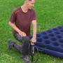 Mann pumpt Luftmatratze mit Bestway Air Hammer Handpumpe (1.850 ml) auf. Camping Zubehör.