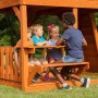 Kinder spielen am Picknicktisch des Backyard Discovery Skyfort II Spielturms.
