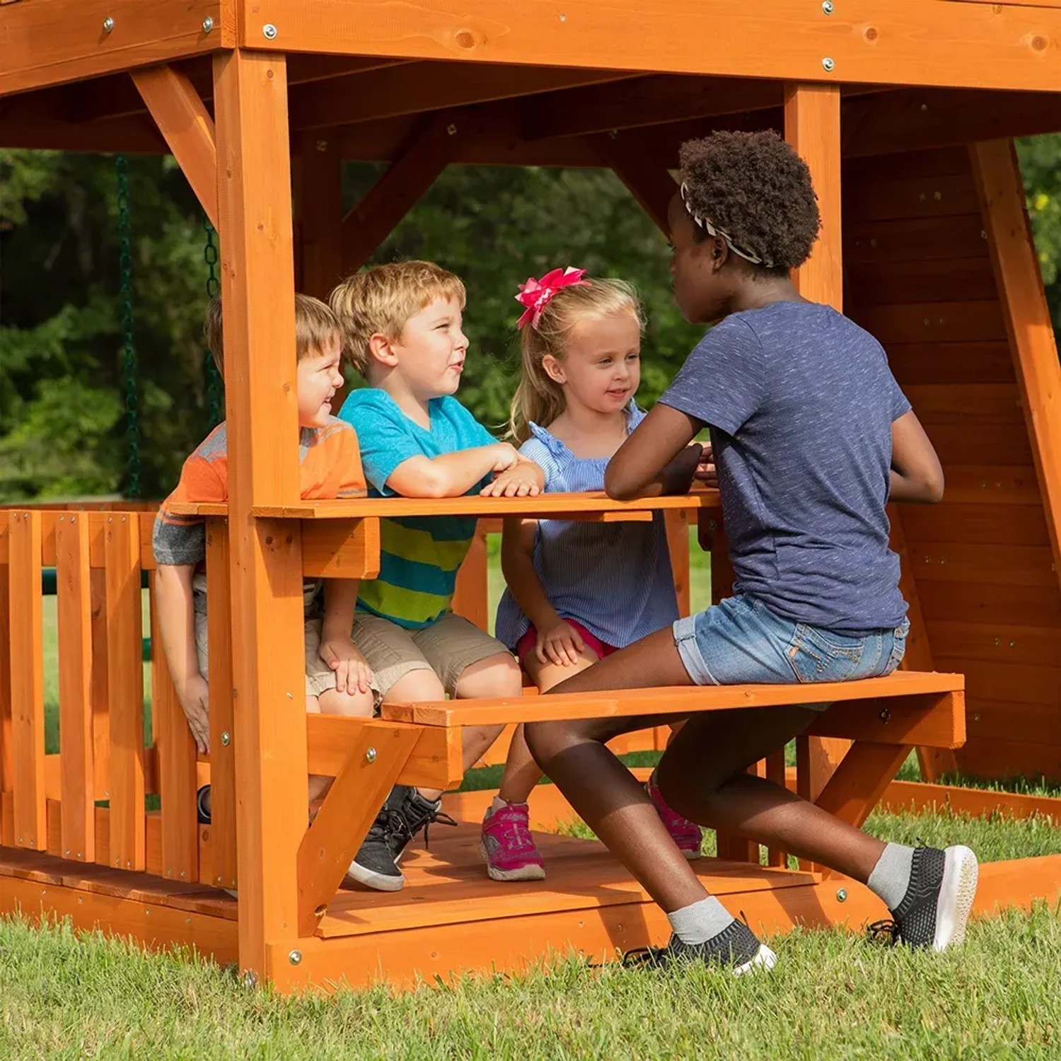 Kinder spielen am Picknicktisch des Backyard Discovery Skyfort II Spielturms.