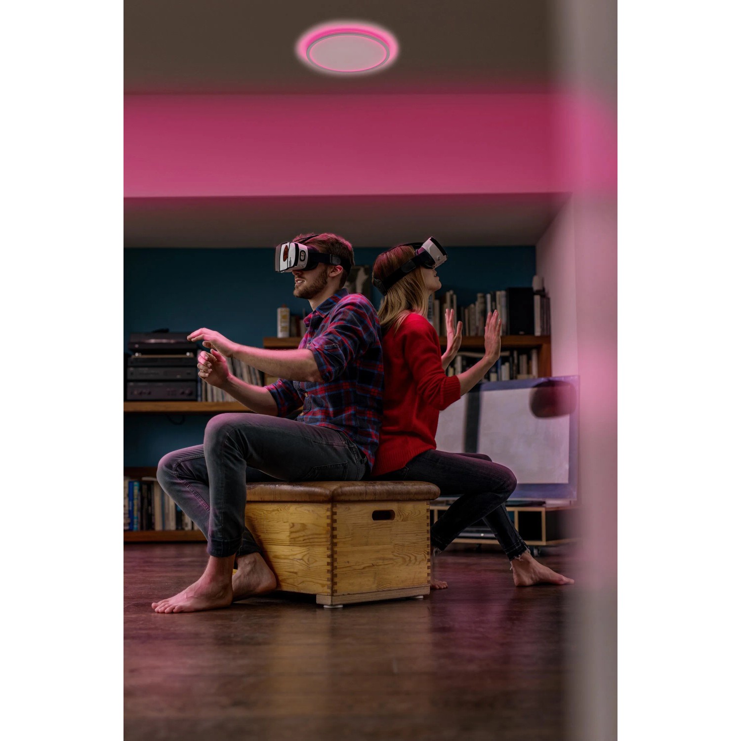 Smarte Ledvance LED-Deckenleuchte Orbis Ultra Slim, schwarz, mit Rücklicht und zwei Personen mit VR Brillen.