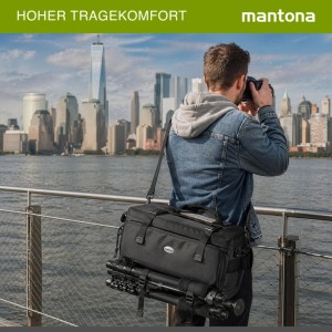 Mantona New York Kameratasche schwarz mit Stativbefestigung, bequem über Schulter getragen von Person, vor Skyline.