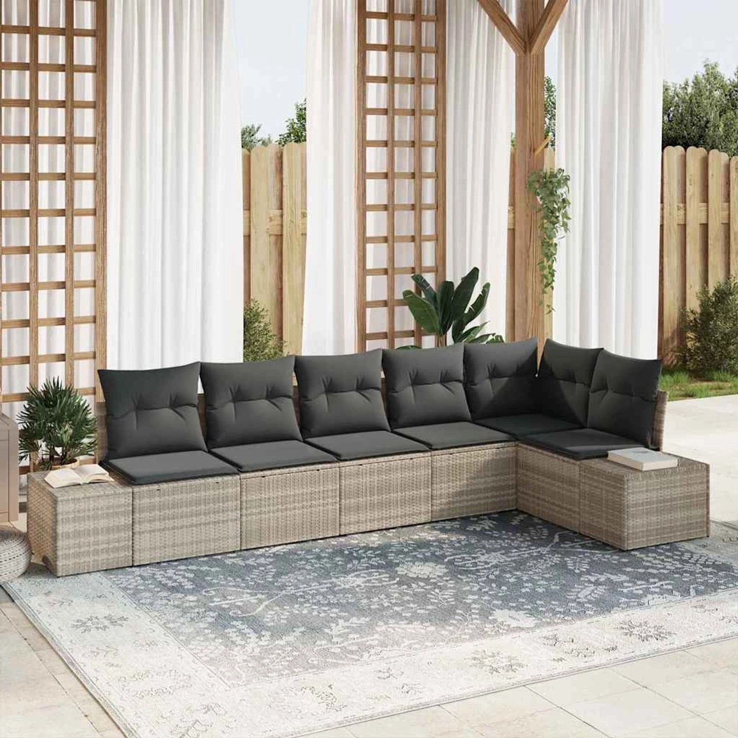 Hellgraues 6-teiliges Gartensofa-Set aus Poly Rattan mit grauen Kissen auf einem gemusterten Teppich.