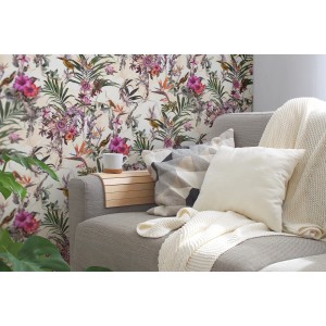Vliestapete mit Blumenmuster in Grün und Beige hinter einem Sofa mit Kissen.