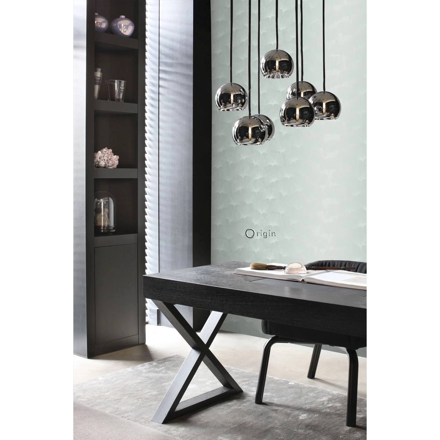 Wohnraum mit Origin Tapete Ginkgoblätter in Seladongrün, kombiniert mit dunklen Möbeln und Lampen.