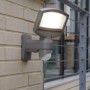 Lutec Solar LED-Strahler Sunshine mit Solarpanel an einer Wand. Außenstrahler mit Bewegungsmelder.