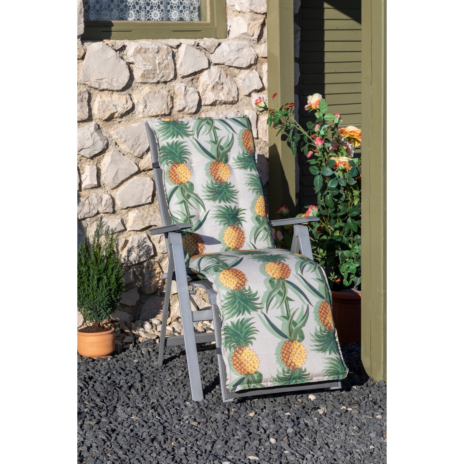 Relaxauflage Treffelstein mit Ananas-Motiv auf Gartenliege. Sitzkissen für entspannte Stunden im Garten.