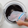 Wäschenetz 3er Set wird in eine Waschmaschine gelegt. Wäscheschutz für Feinwäsche.