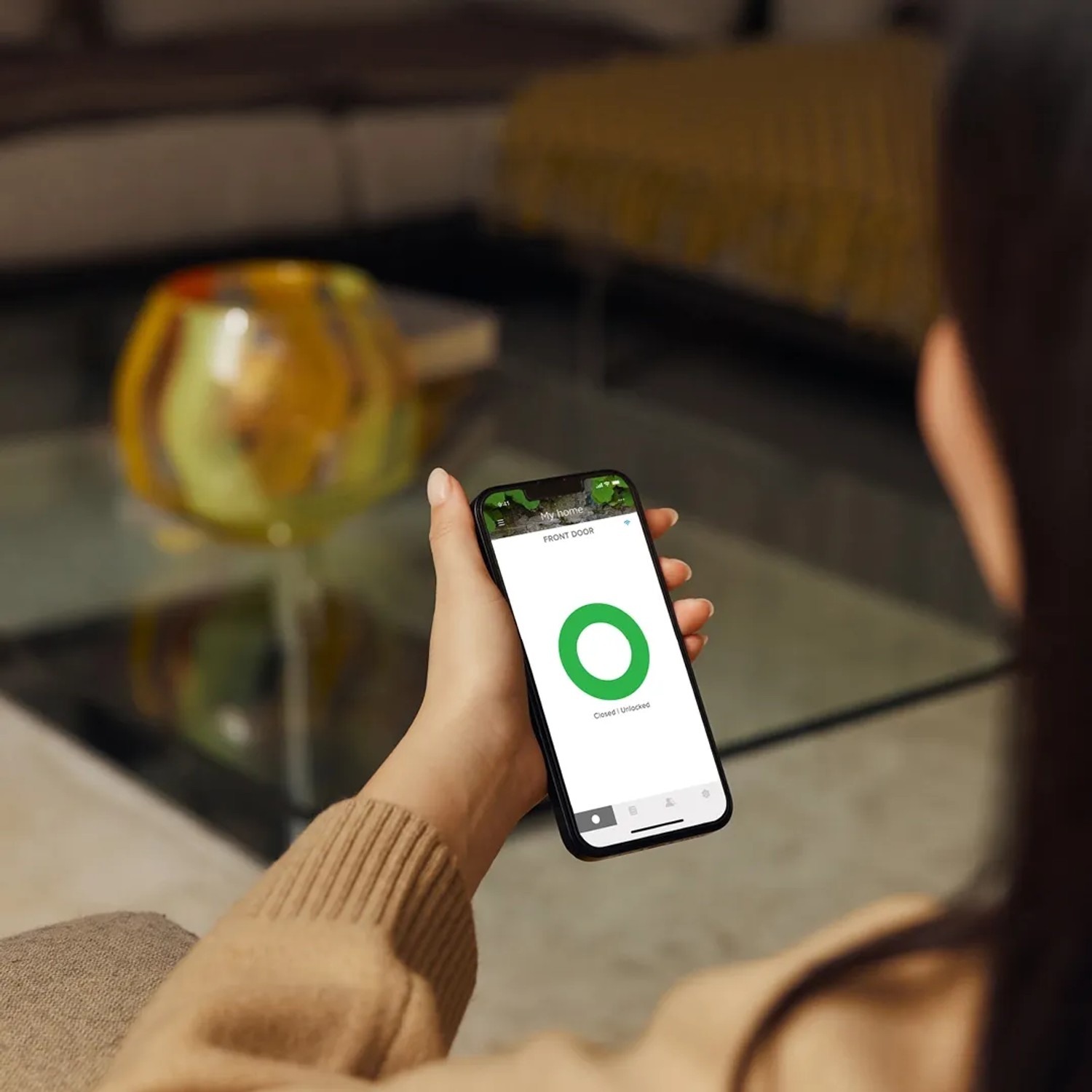 Frau bedient Yale ConnectX WLAN-Bridge per Smartphone App für Smart Home Sicherheit.