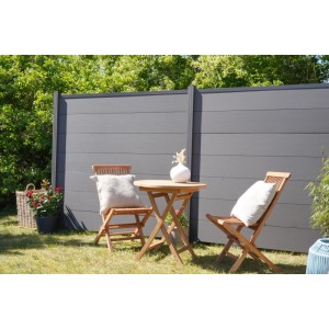 GartenLand WPC Zaun Musterstück XL Ameland schiefergrau, mit Gartentisch und Stühlen im Garten.