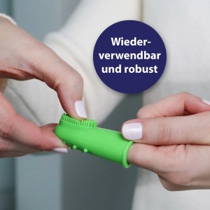 Grüne Canosept Finger-Bürste für Hunde zur Zahnpflege am Finger einer Person.