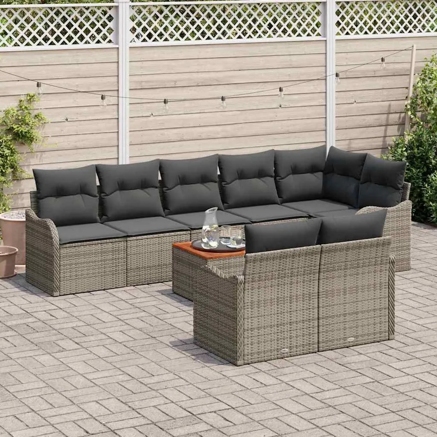Graues 9-teiliges Garten-Sofa-Set aus Poly Rattan mit Tisch und grauen Kissen.