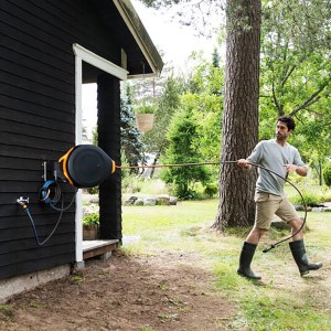 Fiskars Waterwheel XL mit Wandhalterung im Einsatz: Schlauchwagen schwenkbar an Hauswand montiert.