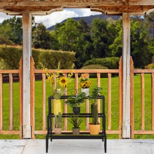 Schwarze Relaxdays Blumentreppe aus Metall mit 3 Stufen, 69x70x60cm, bepflanzt im Garten.