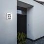 Moderne LED Hausnummerleuchte Alice mit Hausnummer 89 an einer weißen Hauswand.