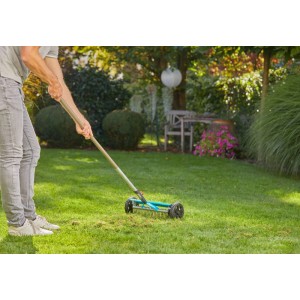 Gardena Combisystem-Vertikutier-Boy in Nutzung: Moosentfernung im Garten mit 32 cm Arbeitsbreite.