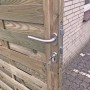 Edelstahl Drückergarnitur mit Ovalrosetten an Holzzaun montiert.